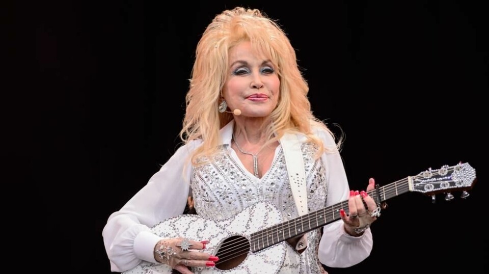 Dolly Parton har gjennom sin karriere etablert seg som en av de mest populære artistene i USA og er av The Wall Street Journal kåret til én av Nord-Amerikas femti mektigste. Her i aksjon på scenen i 2018. Foto: AFP