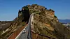 En liten jente løper mot landsbyen Civita. For tiden bor det bare 15 personer i det som omtales som spøkelsesbyen. Foto: Guglielmo Mangiapane / Reuters/NTB