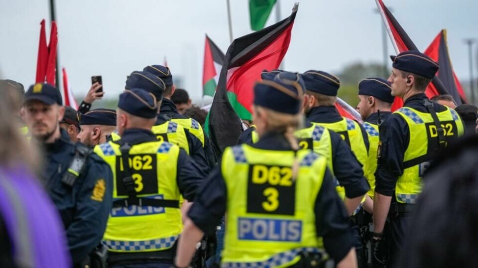 Aktivistene ble presset ut på en sti og ført et stykke unna arenaen av en stor mengde politifolk. Foto: Terje Bendiksby / NTB