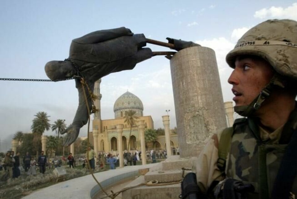 En amerikansk soldat ser på mens en statue av Iraks tidligere president Saddam Hussein blir revet ned i sentrum av Bagdad, 9. april 2003. TB Scanpix/Reuters. En amerikansk soldat ser på mens en statue av Iraks tidligere president Saddam Hussein blir revet ned i sentrum av Bagdad, 9. april 2003. TB Scanpix/Reuters.