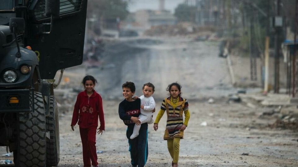 Barn går soldater fra de irakiske spesialstyrkene i møte under en pause i kampene mot IS-krigere i Aden-nabolaget i Mosul onsdag denne uken.
