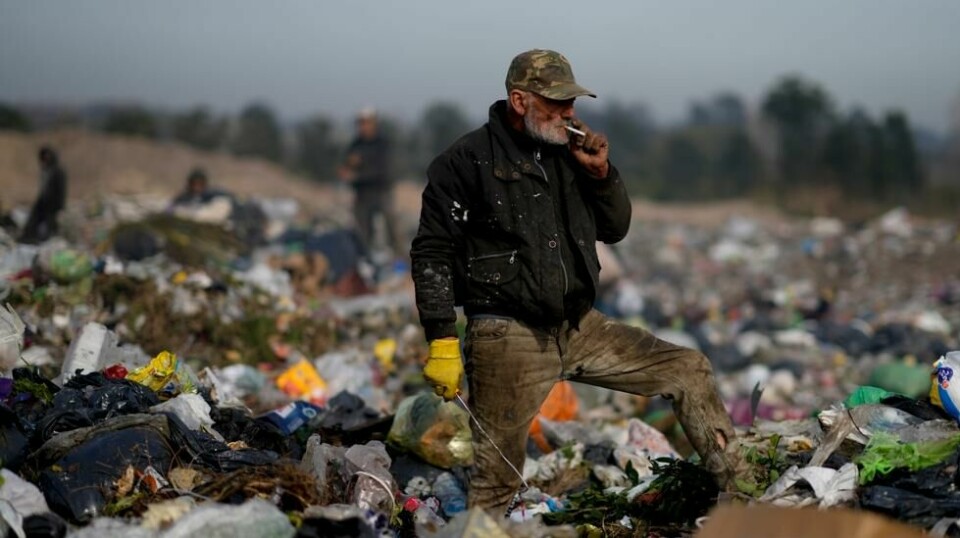 En eldre mann tar seg en røykepause mens han leter etter gjenstander som kan ha verdi på en søppelfylling i Lujan i Argentina. Foto: Natacha Pisarenko / AP / NTB