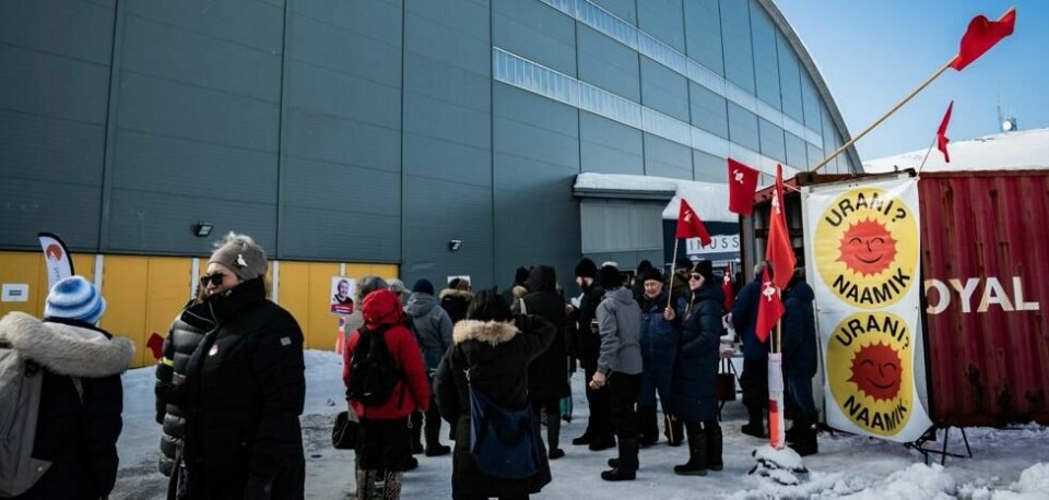 Velgere samlet seg i april foran sportshallen i Nuuk for å stemme. Plakaten til høyre sier 'Uran? Nei, takk.' Velgere samlet seg i april foran sportshallen i Nuuk for å stemme. Plakaten til høyre sier 'Uran? Nei, takk.' Foto: Emil Helms / AFP / NTB