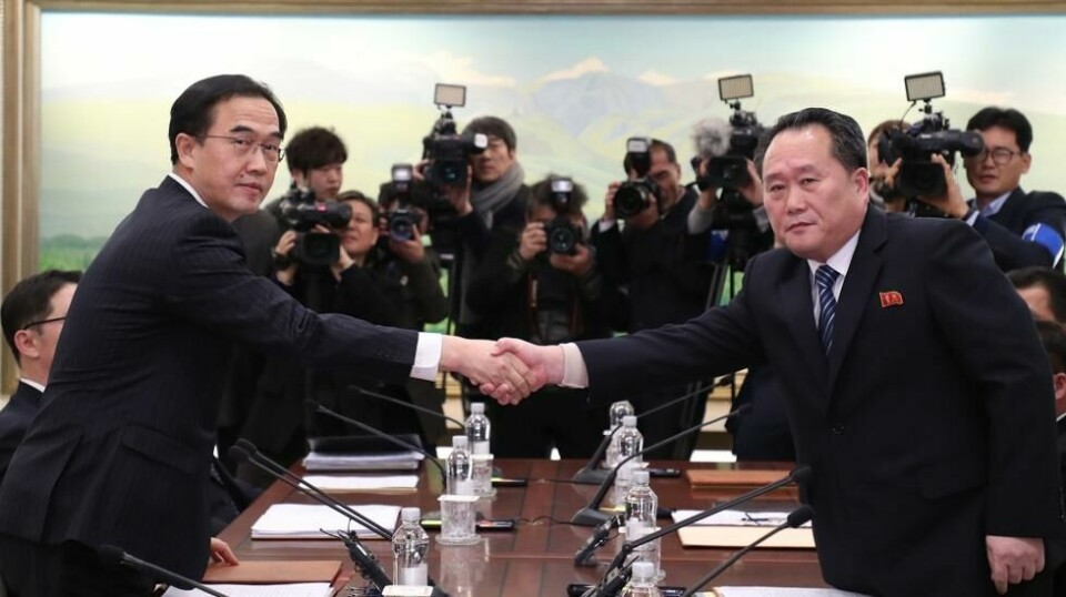Den sørkoreanske gjenforeningsministeren Cho Myoung-gyon (t.v.) tar sin nordkoreanske motpart Ri Son-gwon i hånden under det første møtet mellom de to landene på to år. Foto: AP / NTB scanpix