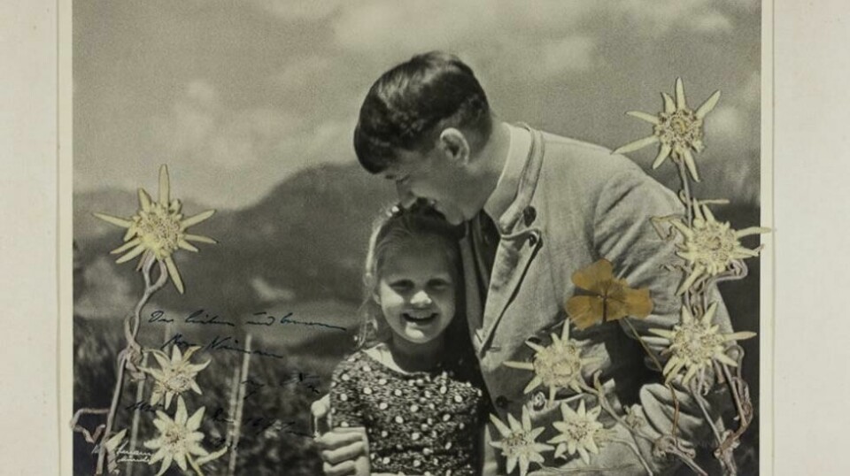 Et tidligere ukjent og unikt bilde av en smilende Adolf Hitler som holder kjærlig rundt en liten jente ble tirsdag solgt på auksjon for 9000 dollar, omlag 75.000 norske kroner. Foto:http://www.alexautographs.com