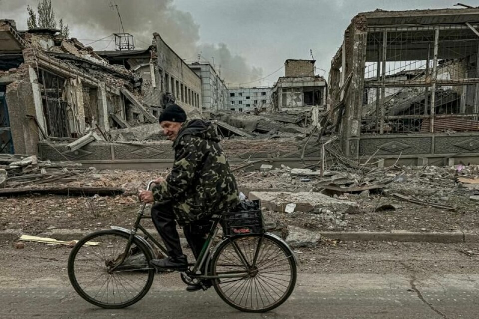 En mann sykler gjennom utbombede områder av byen Kurakhove i Donetsk-regionen. Russerne er på frammarsj. Mange innbyggere har valgt å evakuere, mens andre biter seg fast.