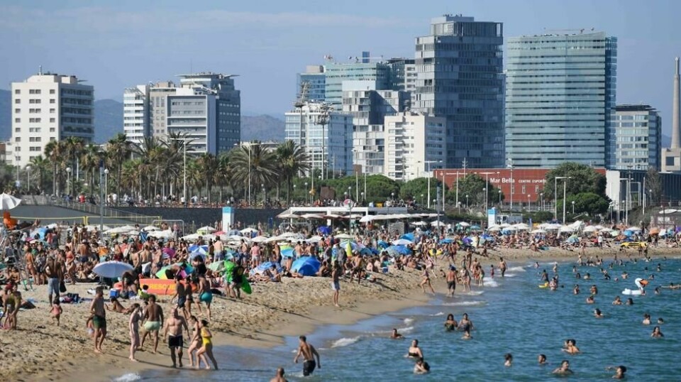 Badegjester på Bogatell-stranden ved Barcelona i Spania. Bilder av folkemassene på spanske strender har vekket oppsikt den siste tiden, samtidig som smitteforekomstene i Spania har økt. Foto: Josep Lago / AFP