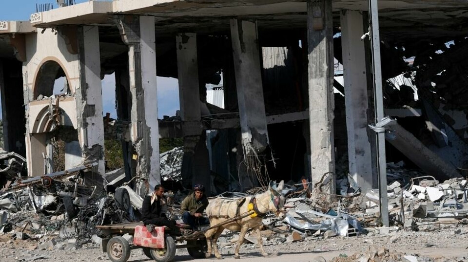 Palestinere på en eselkjerre blant ruinene etter israelske angrep i flyktningleiren Maghazi sentralt på Gazastripen. Tilgangen til mat er svært vanskelig i området, og hjelpeorgansiasjoner advarer mot hungersnød. Foto: Adel Hana / AP / NTB