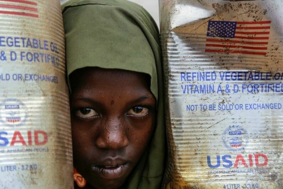 Et internt fordrevet barn kikker ut mellom kanner med matolje sendt av USAID til Maslah-leiren utenfor Mogadishu i Somalia i februar.