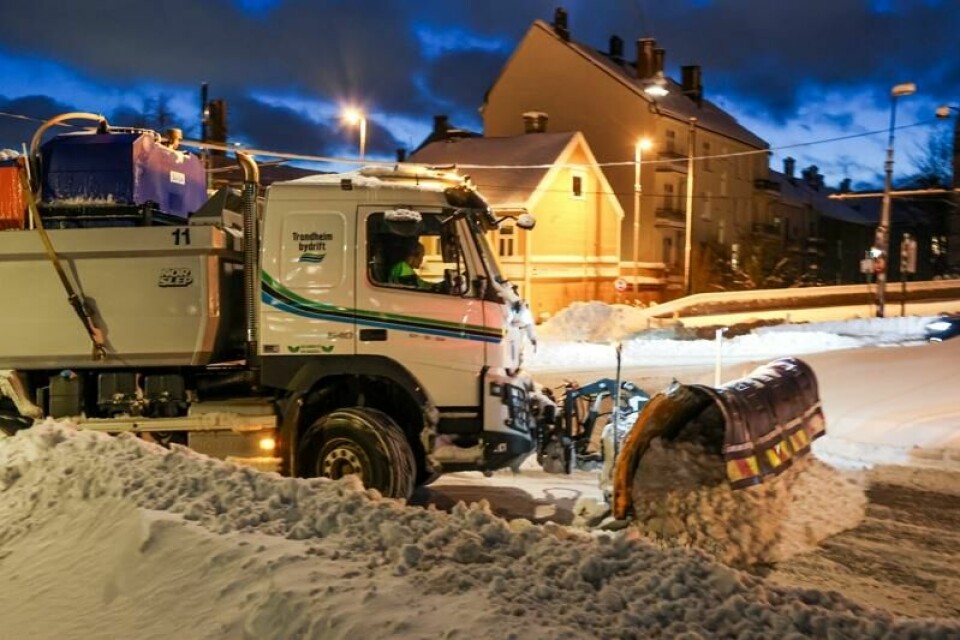 En brøytebil måker seg gjennom Trondheims snøtunge gater.