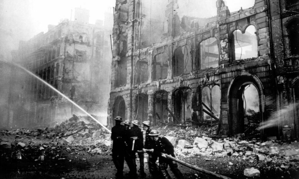 På dette bildet fra 1941 ser vi en gruppe brannmenn kjemper for å slukke flammene i en London-gate som er blitt bombet av tyske fly natten i forveien. Foto: AP På dette bildet fra 1941 ser vi en gruppe brannmenn kjemper for å slukke flammene i en London-gate som er blitt bombet av tyske fly natten i forveien. Foto: AP
