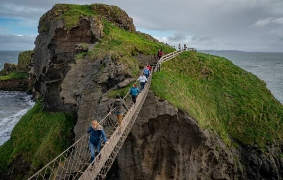 Den lille bruen over til Carrick-a-Rede blir liten i den ellers mektige naturen på Nord-Irlands nordspiss. Foto: Bjørn Moholdt Den lille bruen over til Carrick-a-Rede blir liten i den ellers mektige naturen på Nord-Irlands nordspiss. Foto: Bjørn Moholdt