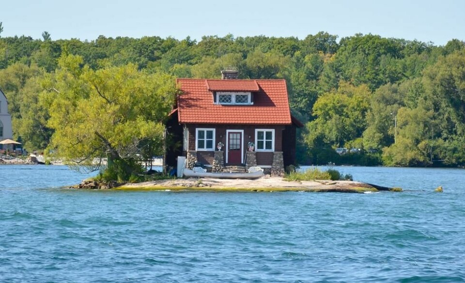 Just Room Enough Island ligger i elven St. Lawrence i Alexandria Bay i New York. Øya er kjent som verdens minste bebodde øy, og har hovedsakelig et hus og et tre. Just Room Enough Island ligger i elven St. Lawrence i Alexandria Bay i New York. Øya er kjent som verdens minste bebodde øy, og har hovedsakelig et hus og et tre. Foto: BakerJarvis / Shutterstock / NTB