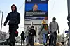 Folk går forbi en elektronisk reklametavle som viser Russlands president Vladimir Putin mens han holder sin årlige statstale i Moskva, 29. februar 2024. Foto: Dmitry Serebryakov / AP