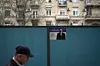 En mann går forbi en valgplakat med bildet av president Ilham Alijev i Aserbajdsjans hovedstad Baku. Den autoritære Aliyev vil denne uka etter alt å dømme sikre seg fem nye år ved makten. Foto: Sergei Grits / AP / NTB