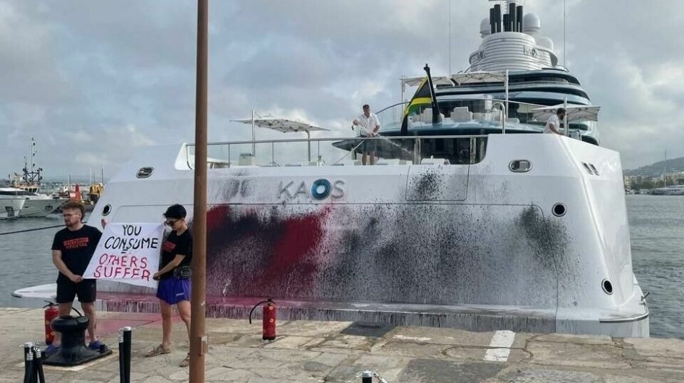 Aktivister foran en yacht med navn Kaos, som de akkurat har spraymalt.