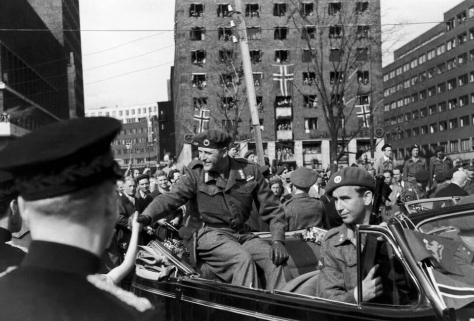 Kronprins Olav får en varm velkomst da han kommer tilbake til Norge 13. mai 1945. Han ble møtt av store folkemengder på Rådhusplassen ved ankomsten. I forsetet sitter Max Manus som bevæpnet livvakt . NTB arkivfoto Kronprins Olav får en varm velkomst da han kommer tilbake til Norge 13. mai 1945. Han ble møtt av store folkemengder på Rådhusplassen ved ankomsten. I forsetet sitter Max Manus som bevæpnet livvakt . NTB arkivfoto