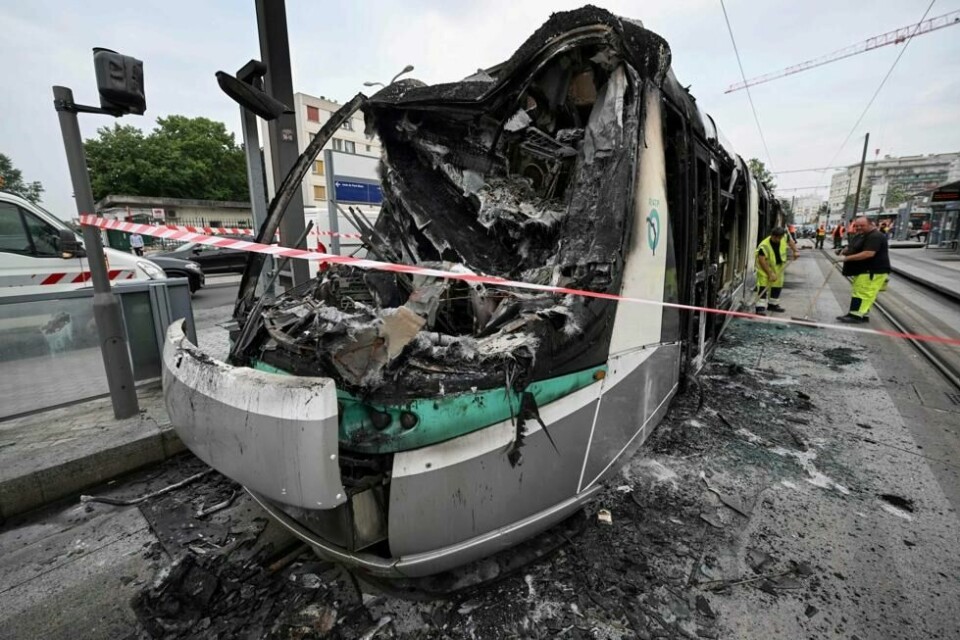 Arbeidere feier opp restene av en brent trikk som ble ødelagt under demonstrasjonene natt til 29.juni 2023, i Clamart, sørvest for Paris. Arbeidere feier opp restene av en brent trikk som ble ødelagt under demonstrasjonene natt til 29.juni 2023, i Clamart, sørvest for Paris. Foto: Emmanuel DUNAND / AFP