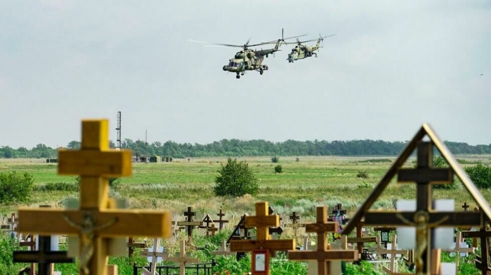 Russiske militærhelikoptre malt med bokstaven Z, flyr bak en kirkegård nær en militær flyplass utenfor Taganrog i Rostov-regionen i Russland 26. juli 2022. Illustrasjonsfoto.
