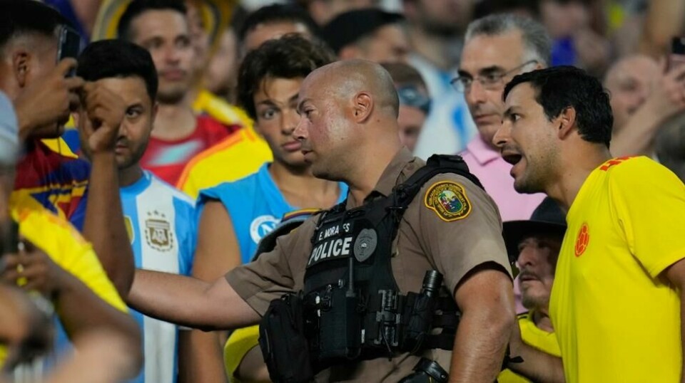 En politimann snakket med supportere på stedet under finalen i Copa America. Foto: Julio Cortez / AP / NTB.