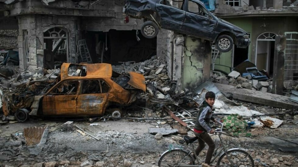 En gutt sykler gjennom ødelagte biler og bygg i et av områdene i Mosul som nylig ble «frigjort» av irakiske sikkerhetsstyrker vest i byen. Scanpix/AP Photo/Felipe Dana.
