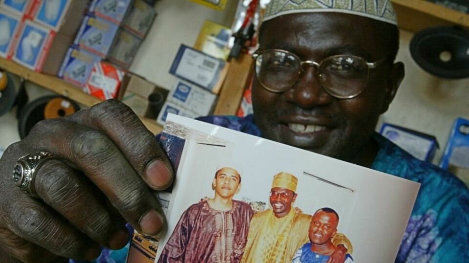 På dette bildet fra 2004 ser vi Malik Obama som holder et udatert bilde der Barack Obama står til venstre ved siden av Malik og en uidentifisert venn i Kenya. Foto: AP/Karel Prinsloo