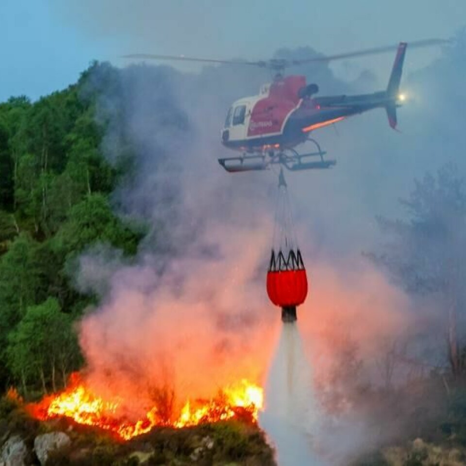 Et skogbrannhelikopter i aksjon under slukking av gressbrann på Sotra tidligere i år. Akkurat nå er risikoen for skogbrann høyest i Finnmark. Foto: Silje Katrine Robinson / NTB