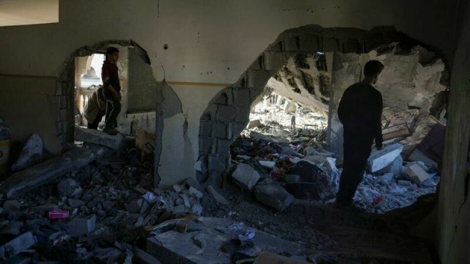 To palestinere ser på ruinene av en bygning som ble ødelagt i det israelske angrepet på Gazastripen natt til tirsdag.