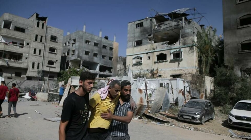 Palestinere hjelper en såret mann etter et israelsk angrep i Nuseirat på Gazastripen forrige uke.