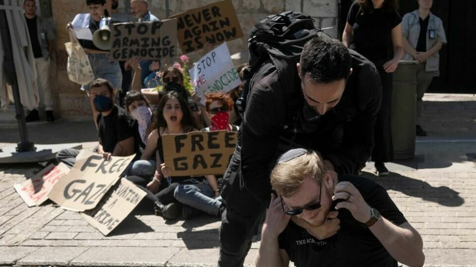 En israelsk politimann fjerner en aktivist fra inngangen til det amerikanske konsulatet i Jerusalem. Aktivistene krever at USA slutter å gi våpen til Israel som brukes i Gaza. Foto: Maya Alleruzzo / AP / NTB