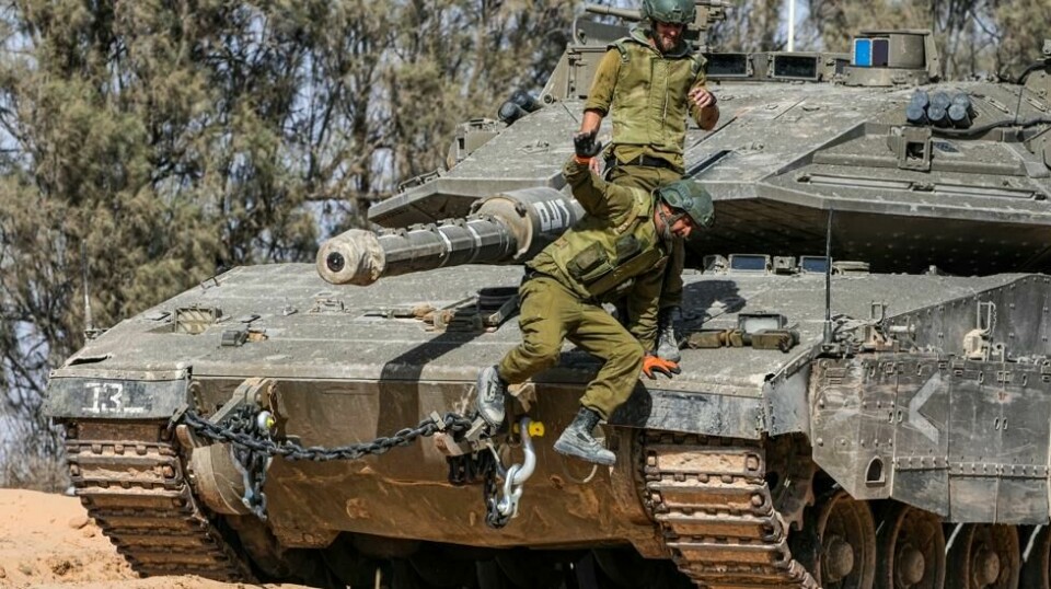 Israelske soldater hopper av en stridsvogn i nærheten av Gazastripen. Organisasjonen for islamsk samarbeid (OIC) fordømmer Israels krigføring på Gazastripen og tar til orde for straffetiltak. Foto: Tsafrir Abayov / AP / NTB