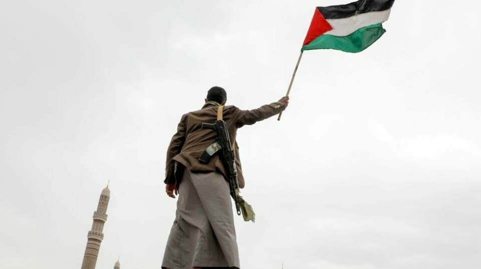 En Houthi-tilhenger vifter et palestinsk flagg under en demonstrasjon mot de USA-ledede angrepene mot Jemen og til støtte for palestinerne på Gazastripen – i Sana i forrige uke. Foto: Osamah Abdulrahman / AP / NTB