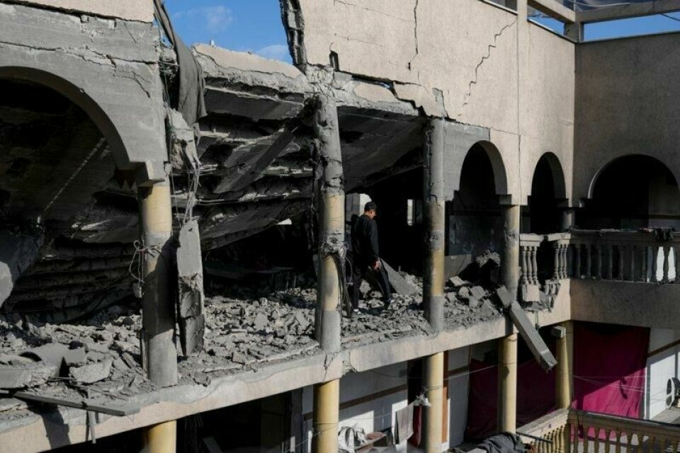 Palestinere går langs en ødelagt skole i Gaza etter de israelske luftangrepene tirsdag.