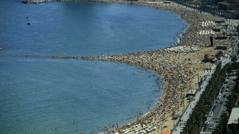 Svært mange gateselgere arbeider ulovlig på Barcelonas populære strand. De har heller ikke utstyr til å håndtere matvarer. Nå advarer spansk politi mot bakterier fra avføring i mat og drinker. Foto: AP / NTB scanpix.