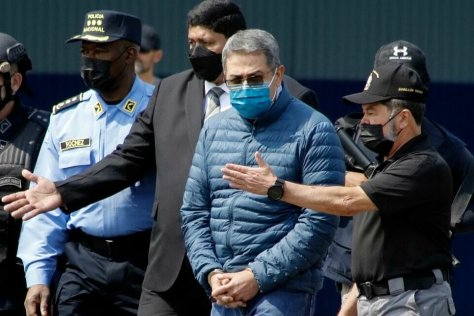 Honduras' tidligere president Juan Orlando Hernandez føres i håndjern til flyet som brakte ham fra hjemlandet til USA da han ble utlevert 21. april 2022. Nå er han dømt til å tilbringe flere tiår i amerikansk fengsel. Honduras' tidligere president Juan Orlando Hernandez føres i håndjern til flyet som brakte ham fra hjemlandet til USA da han ble utlevert 21. april 2022. Nå er han dømt til å tilbringe flere tiår i amerikansk fengsel. Foto: Elmer Martinez / AP / NTB