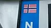 Norsk flagg over hvit N på blå bakgrunn. Og det er kun Statens vegvesen som får lov å lage slike nasjonalitetsmerker.