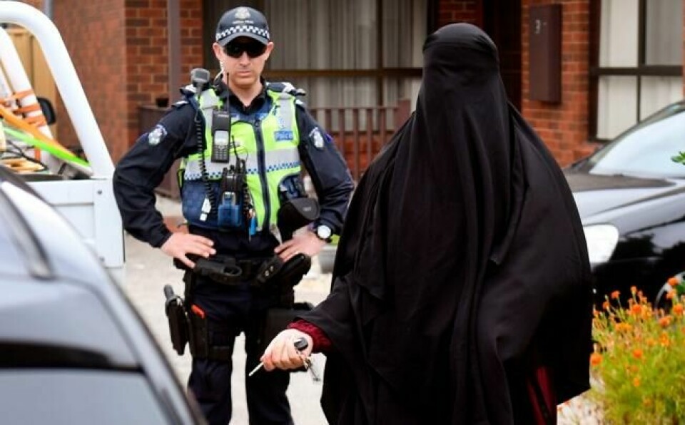 En politibetjent holder vakt mens en kvinne forlater et hus i Melbourne i Australia der politiet gjennomførte en razzia 20. november i år. Tre menn er mistenkt for å ha planlagt et terrorangrep i byen, og ble pågrepet samme dag. NTB Scanpix/AFP. En politibetjent holder vakt mens en kvinne forlater et hus i Melbourne i Australia der politiet gjennomførte en razzia 20. november i år. Tre menn er mistenkt for å ha planlagt et terrorangrep i byen, og ble pågrepet samme dag. NTB Scanpix/AFP.