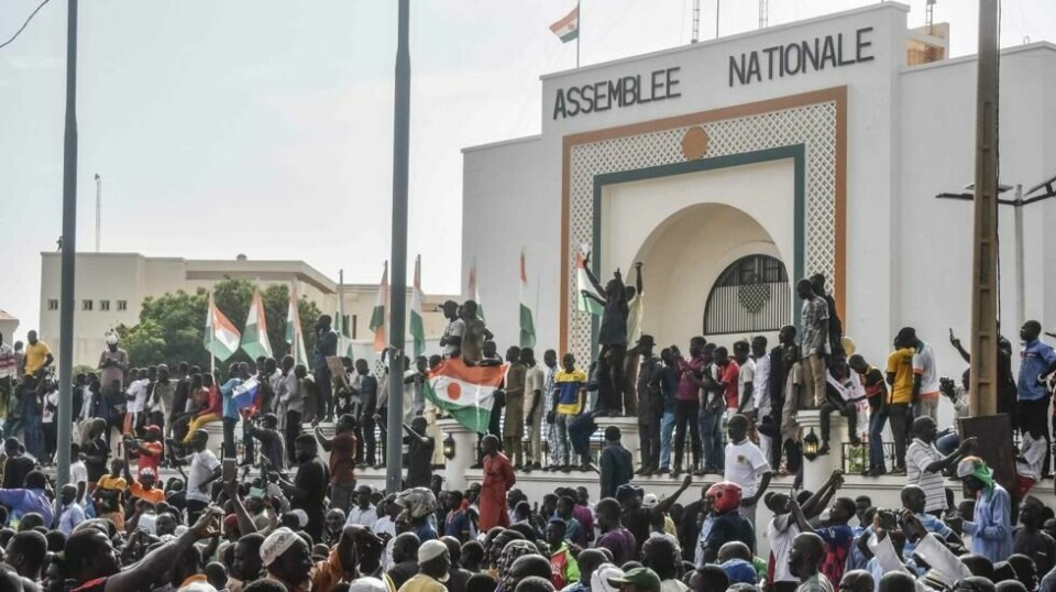 Støttespillere veiver med nigerianske flagg mens de demonstrerer til støtte for Nigers junta foran nasjonalforsamlingen i Niamey, 30 juli 2023.