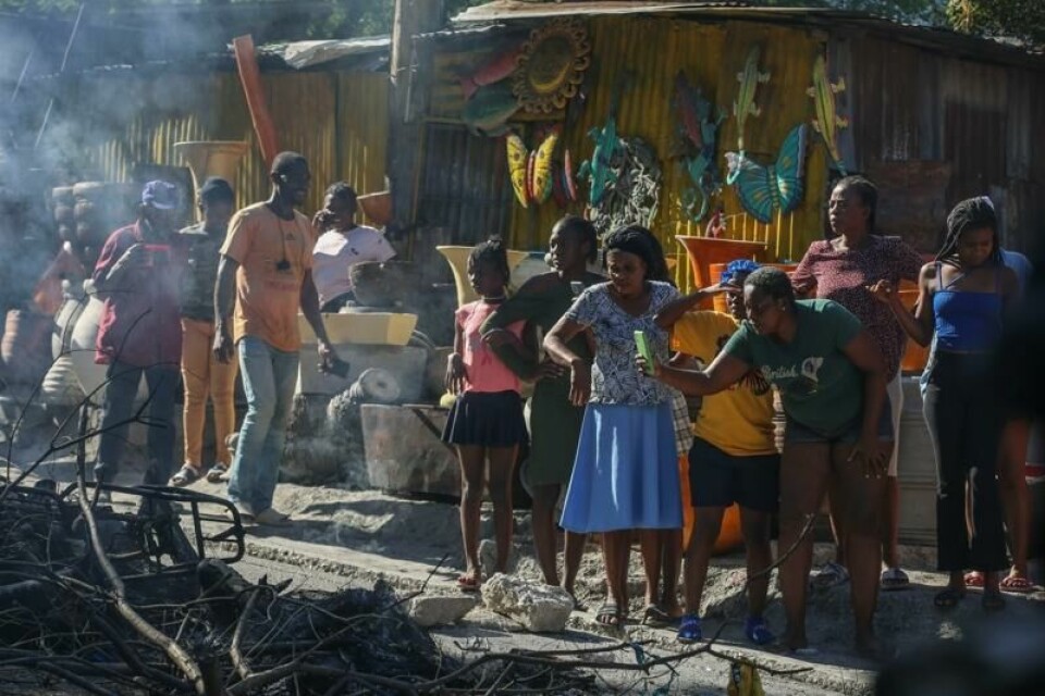 En kvinne filmer det som skal være drepte gjengmedlemmer som så er satt i brann. Rundt 30 mistenkte gjengmedlemmer ble drept av politi og innbyggere i Port-au-Prince-forstaden Petrion-Ville Petion-Ville natt til tirsdag og tirsdag.