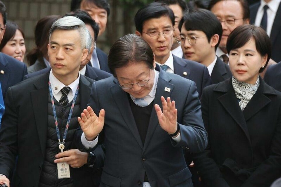 Bildet av Lee Jae-myung (i midten) ble tatt idet han var på vei inn i retten i Seoul onsdag.