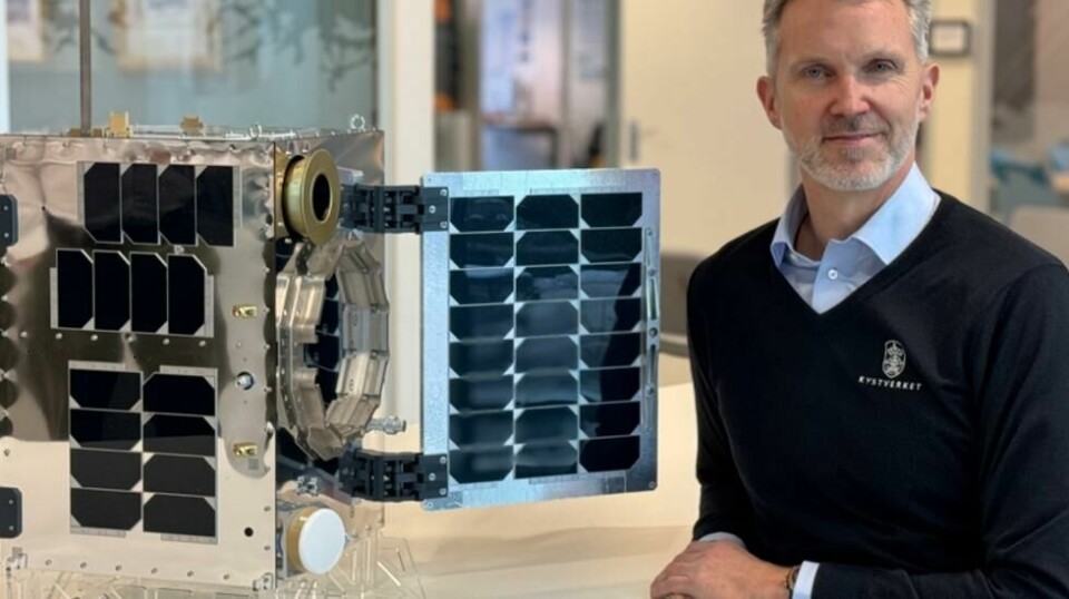 Kystdirektør Einar Vik Arset viser fram en modell av Norsat-4 i faktisk størrelse. Mikrosatellitten ble tirsdag kveld sendt opp i bane rundt jorda.