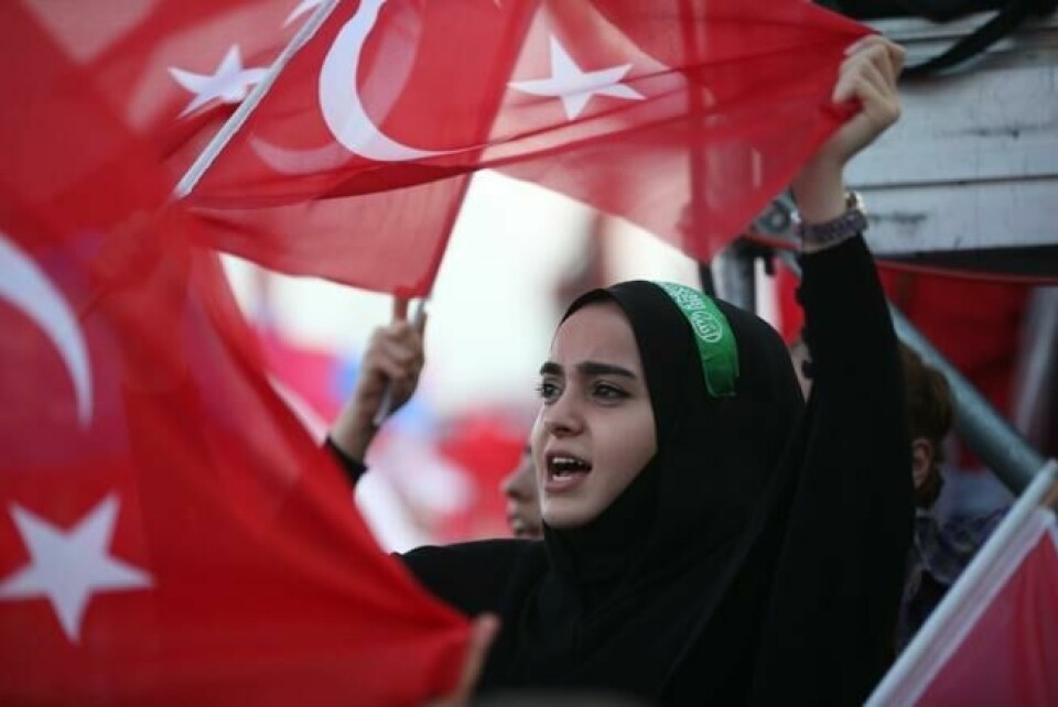 En tilhenger av Tyrkias president Erdogan holder opp det tyrkiske flagg og partiflagget til AKP. Istanbul 17. juni. Scanpix/EPA. En tilhenger av Tyrkias president Erdogan holder opp det tyrkiske flagg og partiflagget til AKP. Istanbul 17. juni. Scanpix/EPA.
