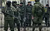 HOLDER VAKT: Ukrainsk soldater bak hovedporten til militærbasen i Perevalne på Krim-halvøya 20. mars 2014. Pro-russisk milits holder vakt utenfor. Foto: Vadim Ghirda / AP