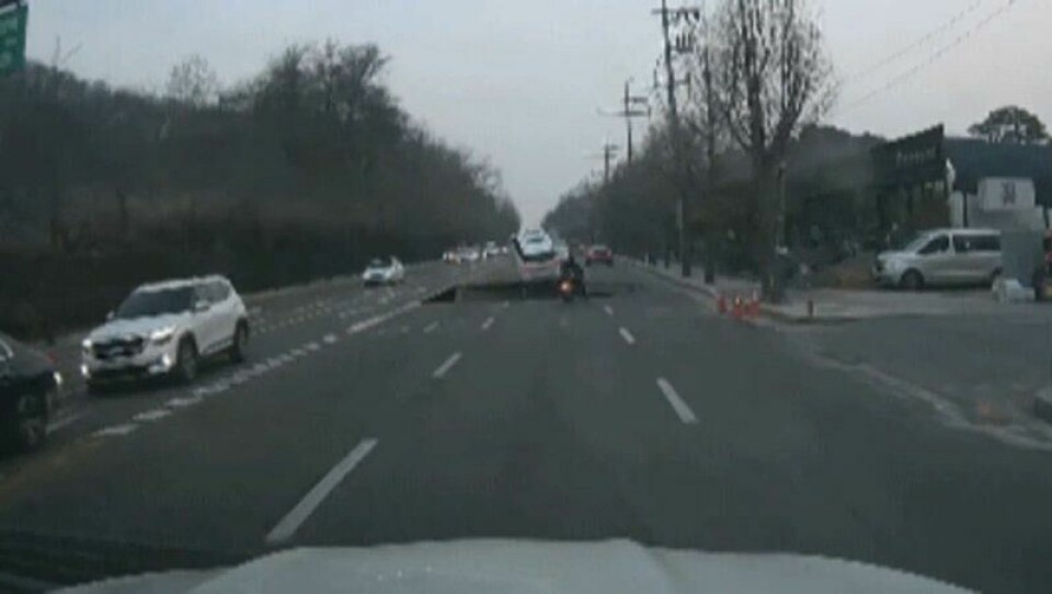 Videoen, som har spredd seg i sosiale medier, skal vise øyeblikket når veien kollapser under motorsyklisten. Videoen, som har spredd seg i sosiale medier, skal vise øyeblikket når veien kollapser under motorsyklisten. Foto: Skjermdump fra dashcam