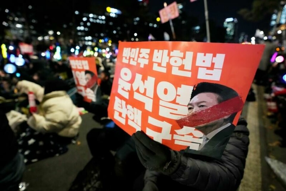 Demonstranter med plakater av president Yoon Suk-yeol utenfor nasjonalforsamlingen.