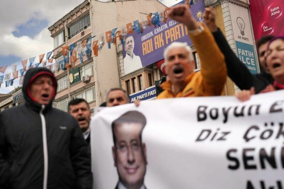 Demonstranter i Istanbul med et banner med bilde av ordfører Ekrem Imamoglu. På bygningen bak henger et banner med bilde av president Recep Tayyip Erdogan.