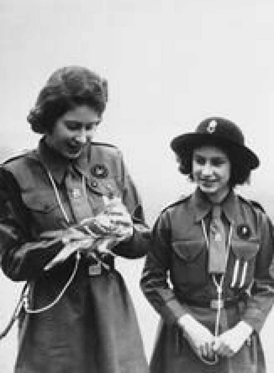Bildet fra 20. februar 1943 viser daværende prinsesse Elizabeth og hennes søster Margaret Rose som skal til å sende et brev med en brevdue. Bildet fra 20. februar 1943 viser daværende prinsesse Elizabeth og hennes søster Margaret Rose som skal til å sende et brev med en brevdue. Foto: AP/NTB