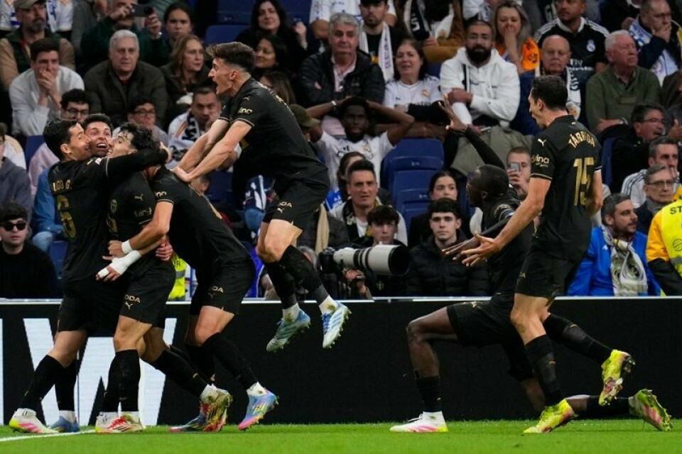 Valencia-spillerne feirer Hugo Duros vinnermål på overtid i bortekampen mot Real Madrid.