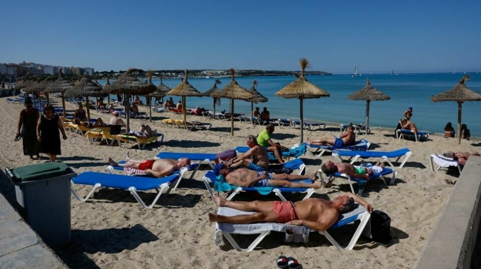Her soler turister seg på en strand på Mallorca.