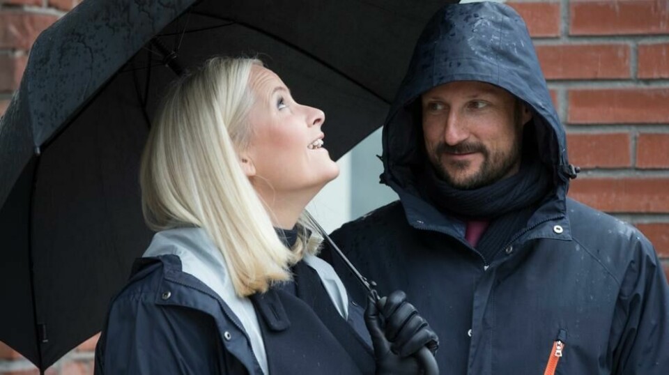 Kronprinsesse Mette-Marit og kronprins Haakon lar seg ikke stoppe av regn – her på besøk Telemark i 2018. Paraply og regntøy er trolig beste valg på fylkesturens første dag. Foto: Terje Pedersen / NTB